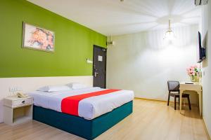 新山HOTEL 101 PERMAS JAYA的一间卧室配有一张带绿色墙壁的床