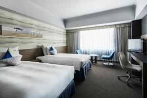 金泽金泽ANA皇冠假日酒店的酒店客房配有两张床和一张书桌