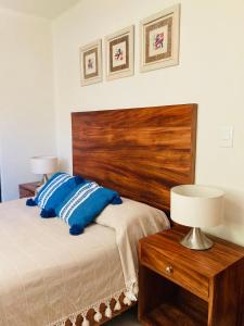 圣克鲁斯华特库El Colorín, a condo in the heart of Huatulco的一间卧室配有一张带木制床头板的床
