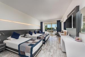 科纳克勒White City Beach Adult Only的酒店客房设有两张床和电视。