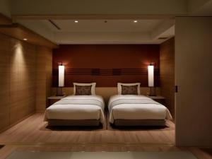 神户神户凑温泉仁酒店的一间卧室配有两张床,墙上有两盏灯