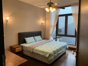 Kampong TengCA Homestay Borneo Highland的一间卧室设有一张床和一个大窗户