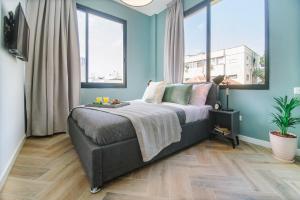 特拉维夫Monochrome Rothschild - Smart Hotel by Loginn Tel Aviv的一间卧室配有一张蓝色墙壁和窗户的床