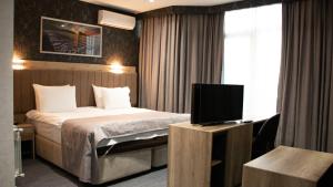巴库Home Suites Baku-Halal Hotel的配有一张床和一台平面电视的酒店客房