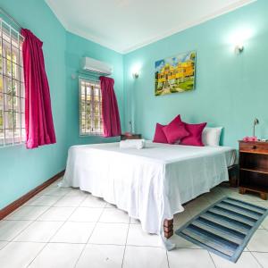 马埃岛博瓦隆公寓的一间卧室配有一张带蓝色墙壁的大床