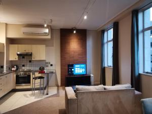 约翰内斯堡Mapungubwe Hotel Apartments Marshalltown的带沙发的客厅和厨房