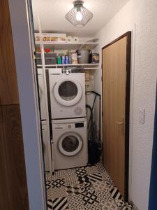 瓦卢瓦尔Studio cosy et chaleureux的小型洗衣房配有洗衣机和烘干机