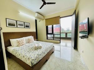 古尔冈BluO 2BHK Golf Course Road, Balcony, Lift, Parking的一间卧室,床上有两双鞋