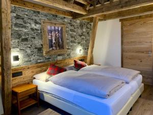 阿拉巴甘智亚娜酒店的一间卧室设有一张大床和石墙