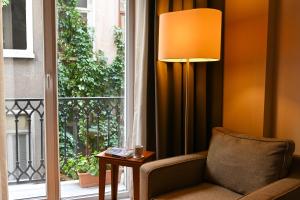 伊斯坦布尔11号酒店公寓的一间带椅子、一盏灯和一扇窗户的房间