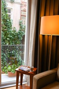 伊斯坦布尔11号酒店公寓的坐在窗边桌子上的一盏灯