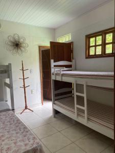 伊列乌斯Casa Amarela na praia para 13 pessoas的一间卧室设有两张双层床和一扇窗户。