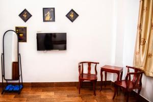 芹苴An Nam Corner - CanTho的一间设有两把椅子和一台墙上的电视的房间
