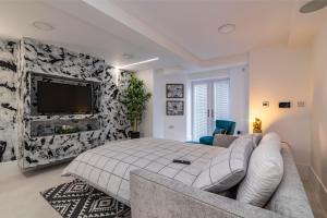 诺丁汉Garden Apartment West Bridgford的一间卧室配有一张床、一张沙发和一台电视。