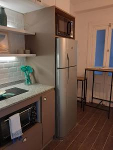 布宜诺斯艾利斯San Telmo Suites的厨房配有不锈钢冰箱和微波炉。