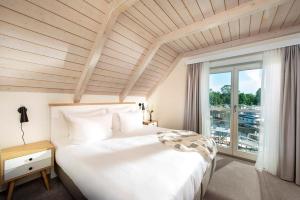 克雷泽朗Precise Resort Marina Wolfsbruch的卧室设有一张白色大床和一扇窗户。
