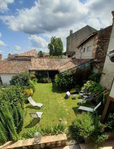 AuvillarGite de la Sauvetat的一个带草坪椅的庭院和一座建筑
