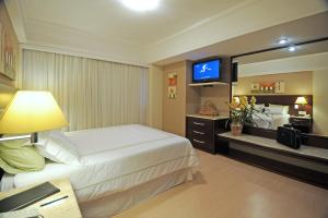 隆德里纳波旁隆德里纳商务酒店的酒店客房,配有床和电视