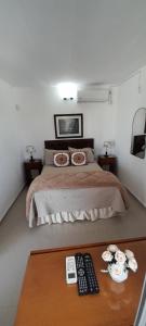 科洛尼亚-德尔萨克拉门托Apartamento Familiar Marta的一间卧室,配有一张带两张遥控器的桌子