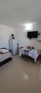 科洛尼亚-德尔萨克拉门托Apartamento Familiar Marta的客房设有两张床、一张桌子和一台冰箱