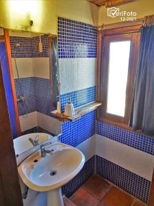 德尔迪阿布罗角La Posada的蓝色瓷砖浴室设有水槽和窗户