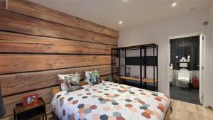 布鲁塞尔切斯爱萨马拉菲利普公寓的一间卧室设有木墙和一张床