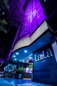 墨西哥城LaiLa Hotel CDMX Reforma的一座建筑,在晚上前有标志