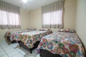 纳塔尔Apartamento Climatizado em Natal por Carpediem的带两张床和两个窗户的房间