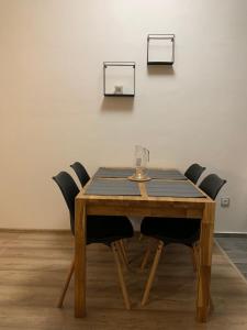 克拉利基Apartmán na náměstí的一张带椅子的木桌和一杯葡萄酒