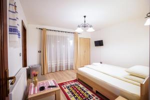 下维谢乌乡Casa Luca的一间卧室配有一张床和一张桌子,铺有地毯