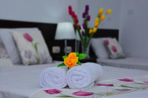 塔拉波托Residencial Lago Verde的床上两条毛巾和一朵花