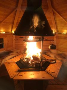 SlagnäsModern Lapland Cottage with Outdoor Sauna & BBQ Hut的小屋内的壁炉,里面设有壁炉
