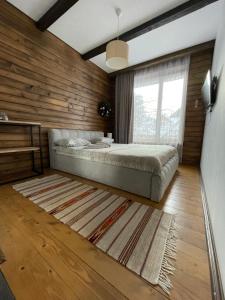 亚列姆切Girske Povitria 2的一间卧室设有一张床和木墙