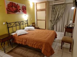 特尔斐匹托酒店的一间卧室配有一张大床和一把椅子