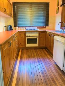 高勒Rustic on 13th的厨房配有木制橱柜和白色炉灶烤箱。