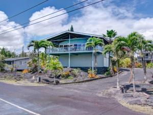 凯阿奥Hawaiian Paradise的一座棕榈树的蓝色房子
