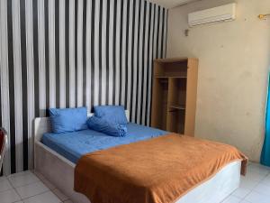 庞卡兰布翁ASOKA GUEST HOUSE的一间卧室配有一张带蓝色枕头的床。