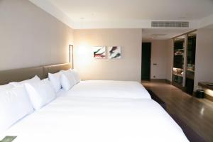 台东The Gaya 渡假酒店的卧室配有带白色枕头的大床