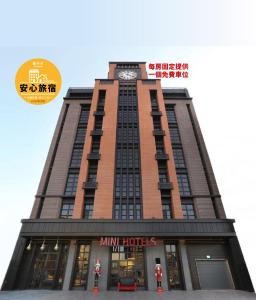 台中市MINI HOTELS(逢甲館)的一座高大的建筑,上面有钟