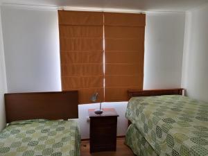 埃尔基斯科Casas Isla Negra的一间卧室设有两张床和一张桌子上的台灯。