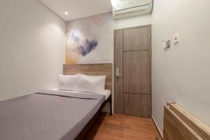 诗都阿佐Livinn Juanda Airport Surabaya的一间小卧室,配有一张床和一扇门