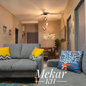伯恩仓Mekar KH Homestay (Muslim) @ Brinchang的客厅配有灰色的沙发和黄色的枕头。