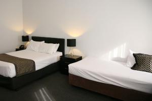 墨尔本福特斯克瑞汽车旅馆加服务式公寓酒店的配有2盏灯的酒店客房的2张床