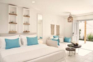 卡马利Nikki Beach Resort & Spa Santorini的卧室配有白色大床和蓝色枕头