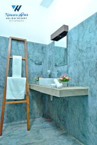 阿努拉德普勒Nuwara Wewa Holiday Resort的一间带水槽、镜子和椅子的浴室
