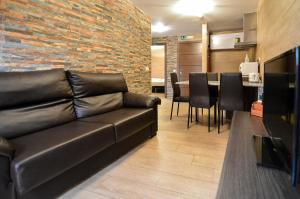 托莱多托莱多旅游公寓的客厅设有真皮沙发和酒吧。