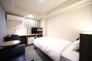 川崎柯丽格亚广场酒店的酒店客房,配有床和电视
