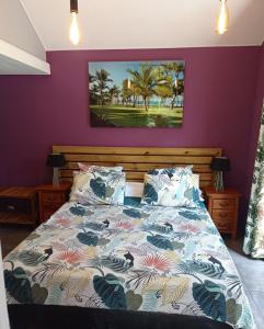 Manapany-les Bains玛格伊拉住宿加早餐旅馆的一间卧室配有一张紫色墙壁的床