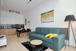 弗罗茨瓦夫Green Ande的一间带蓝色沙发的客厅和一间厨房