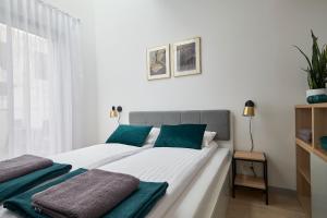 弗罗茨瓦夫Green Ande的一间卧室配有一张带白色和蓝色枕头的床